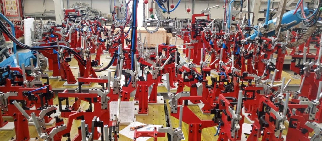 Precision red assembly jigs on the production floor